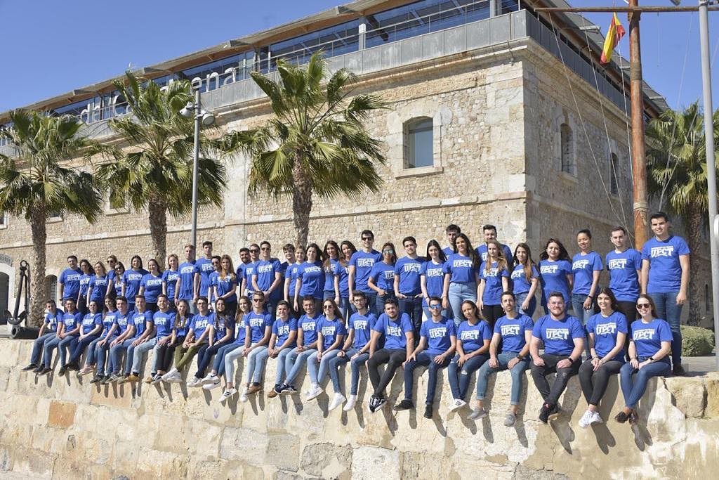 Muestra una promoción de estudiantes de la Facultad de Ciencias de la Empresa frente al edificio de la Facultad