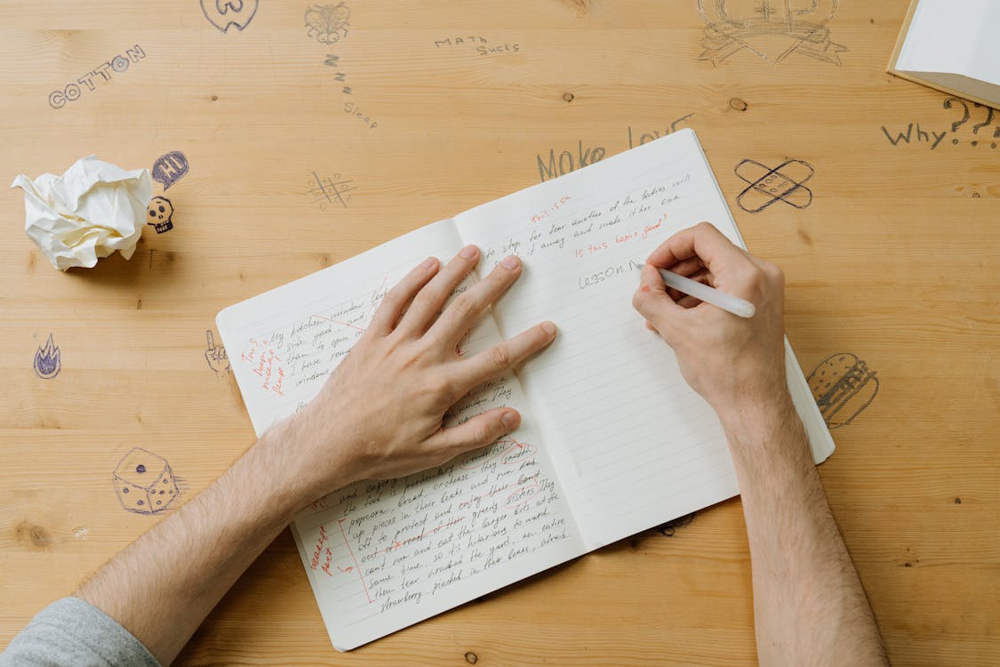persona escribiendo sobre una libreta