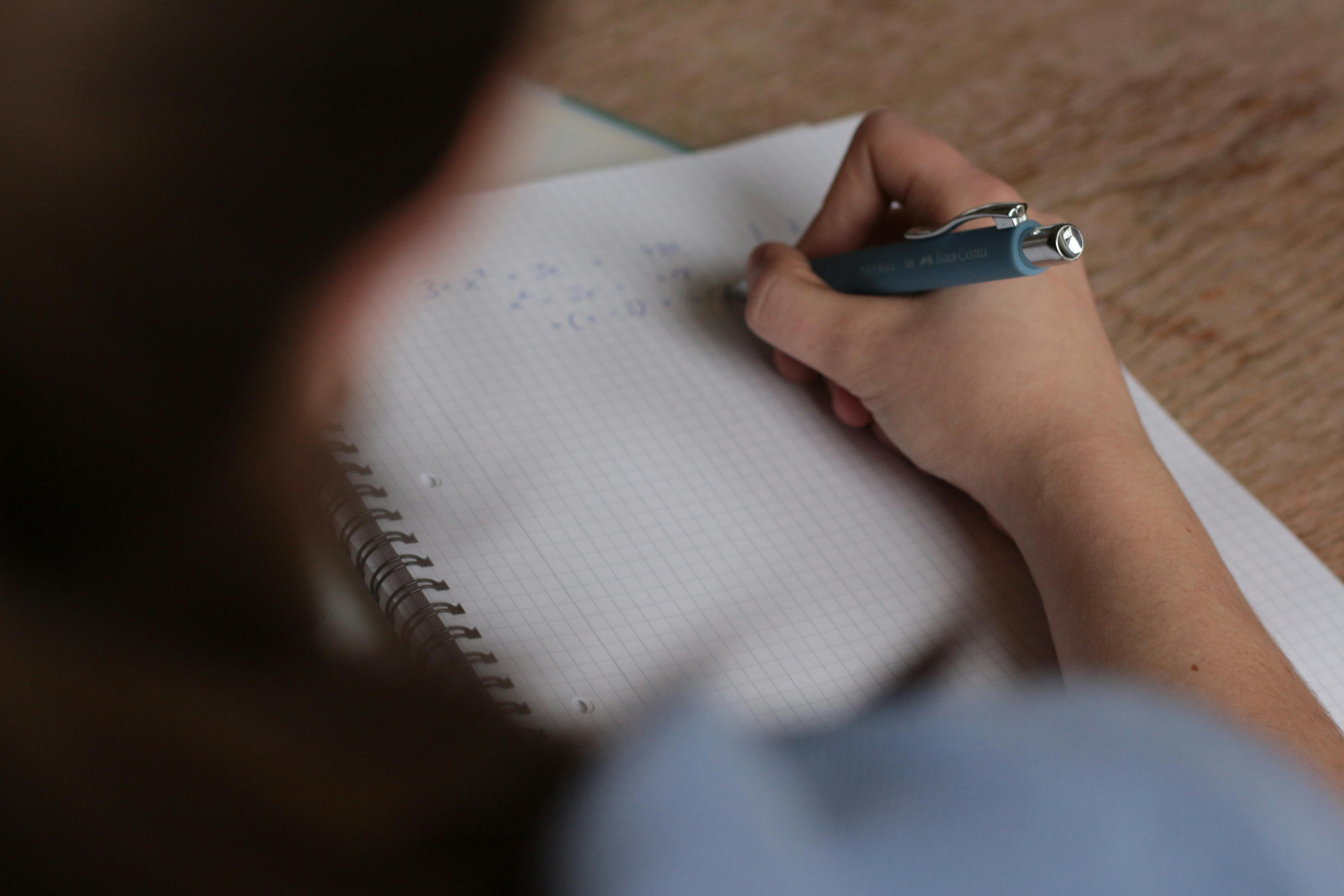 persona escribiendo sobre una libreta