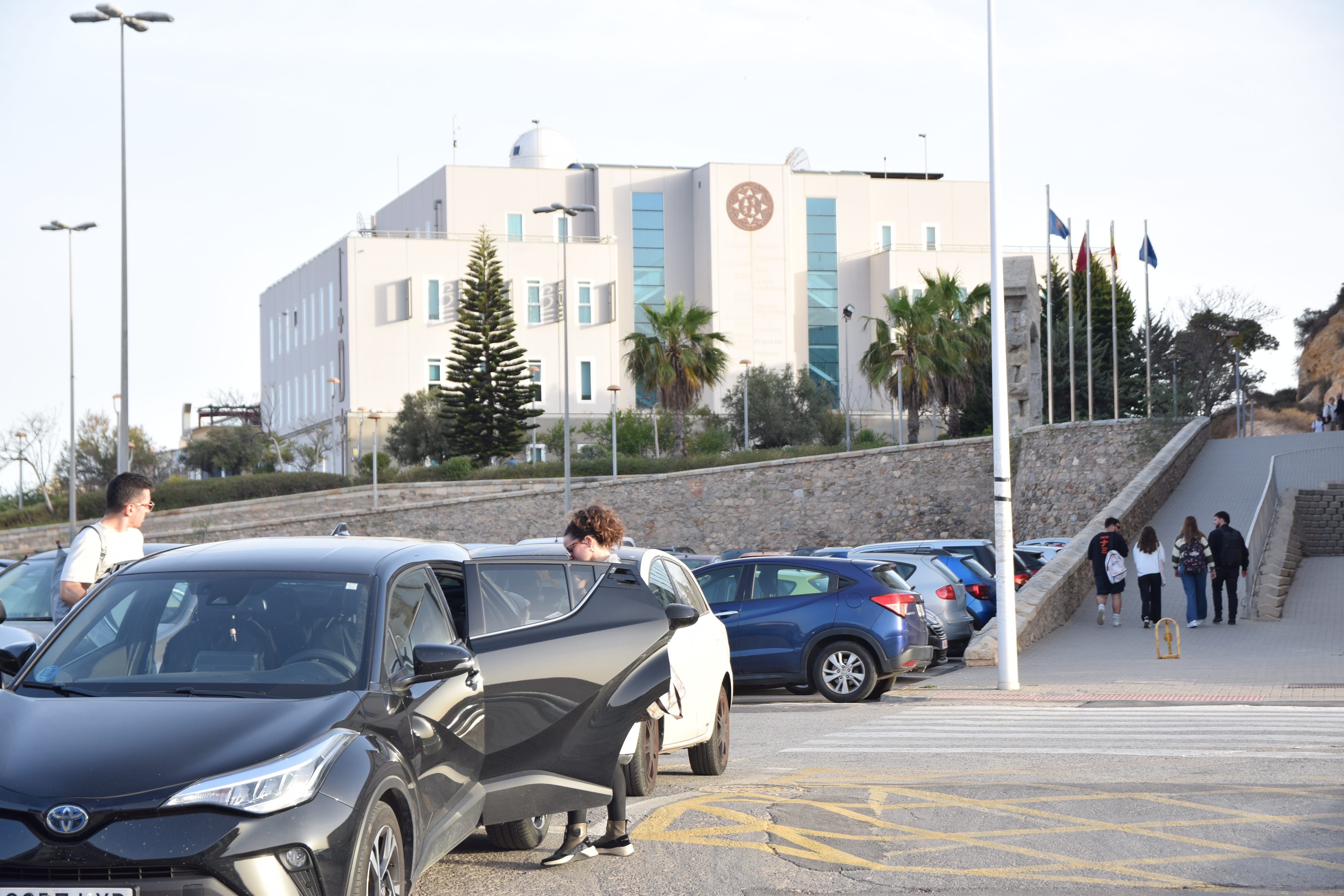 Estudiantes saliendo de un coche en un parking UPCT